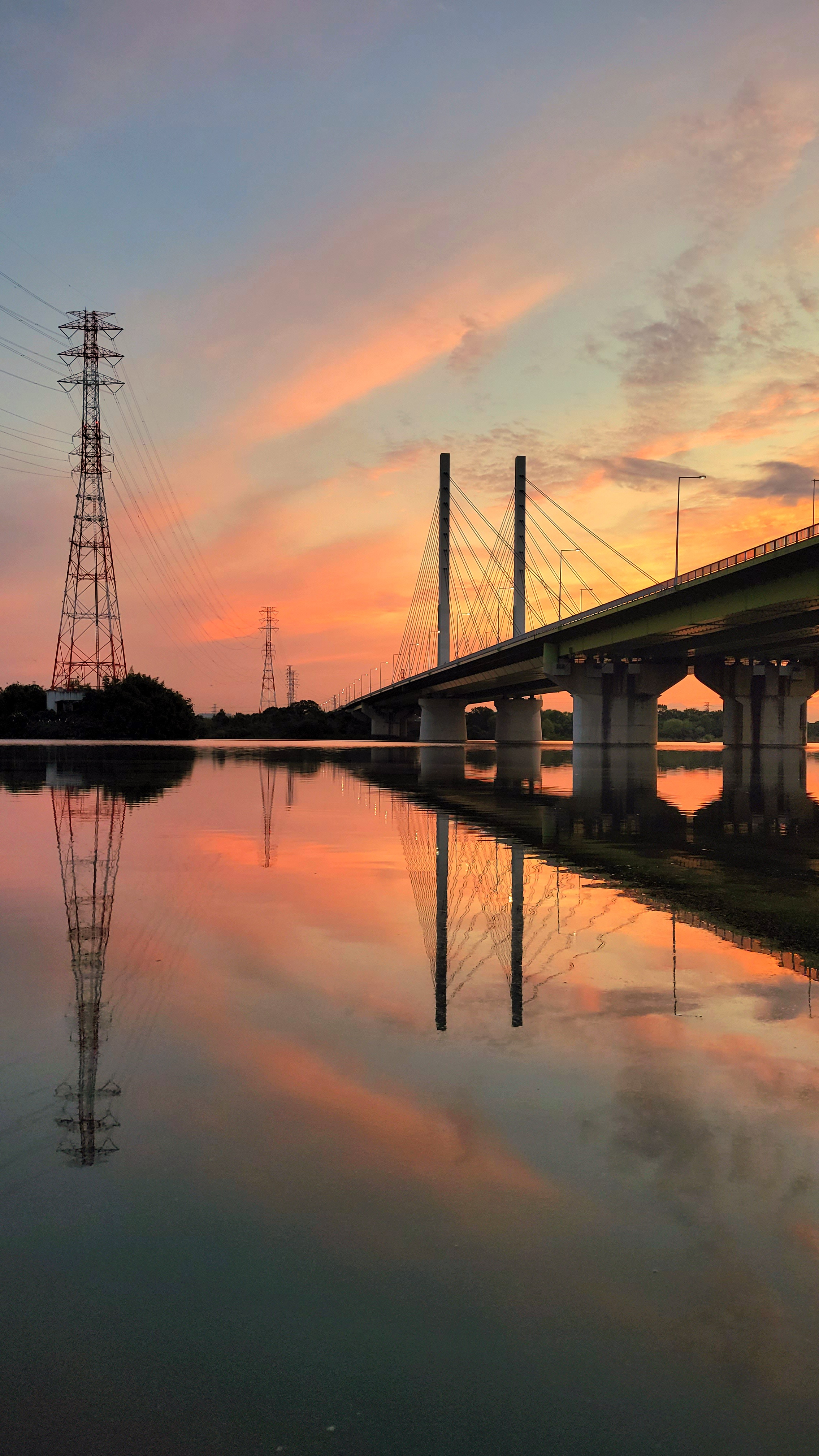 荒川土手にて、「彩湖に映る夕日と幸魂大橋の幻想的な光景」と感じた写真です。