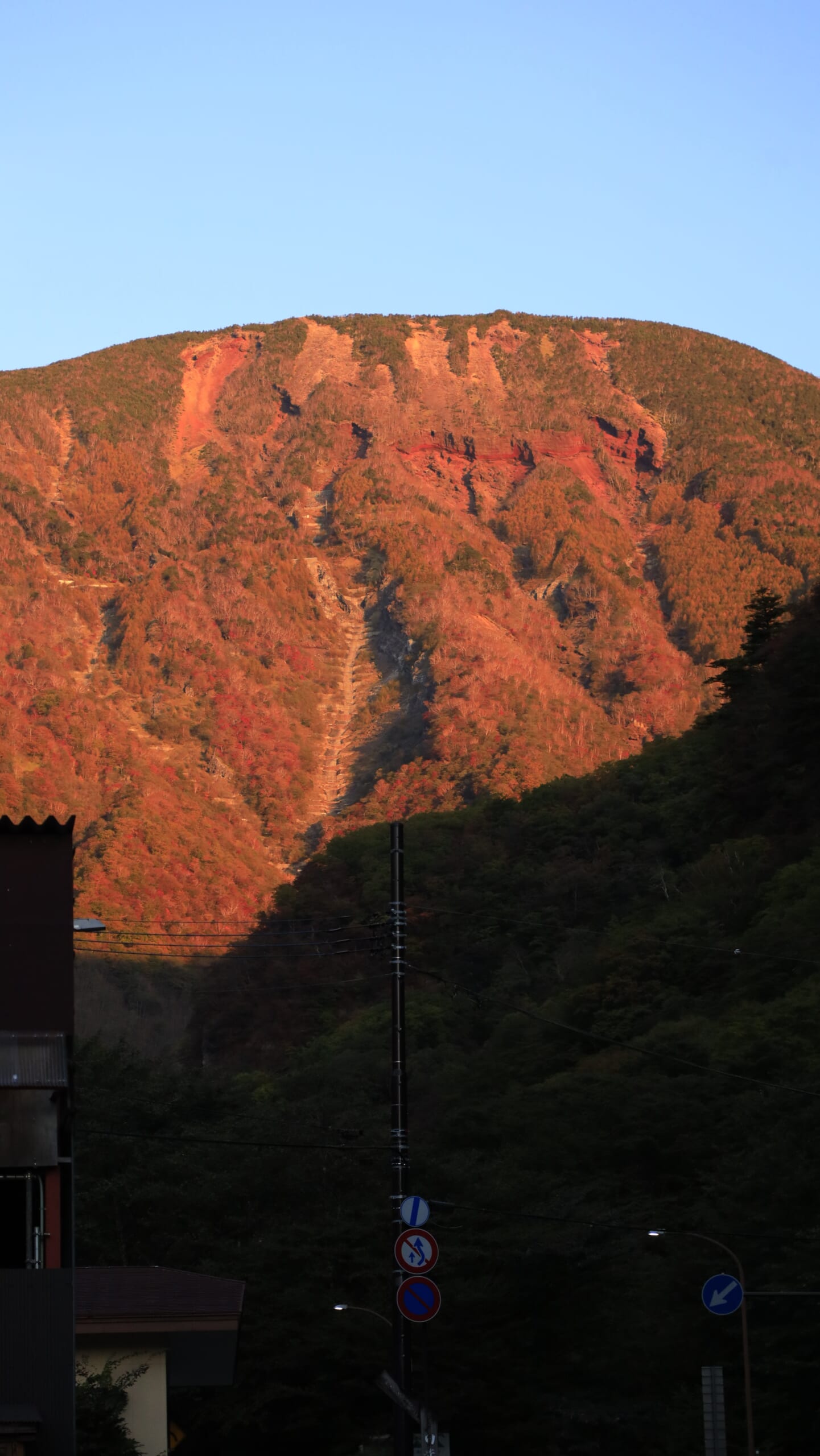 奥日光の男体山付近で、早朝の朝日に山肌が照らされ、雄大な姿が浮かび上がる秋の男体山の風景