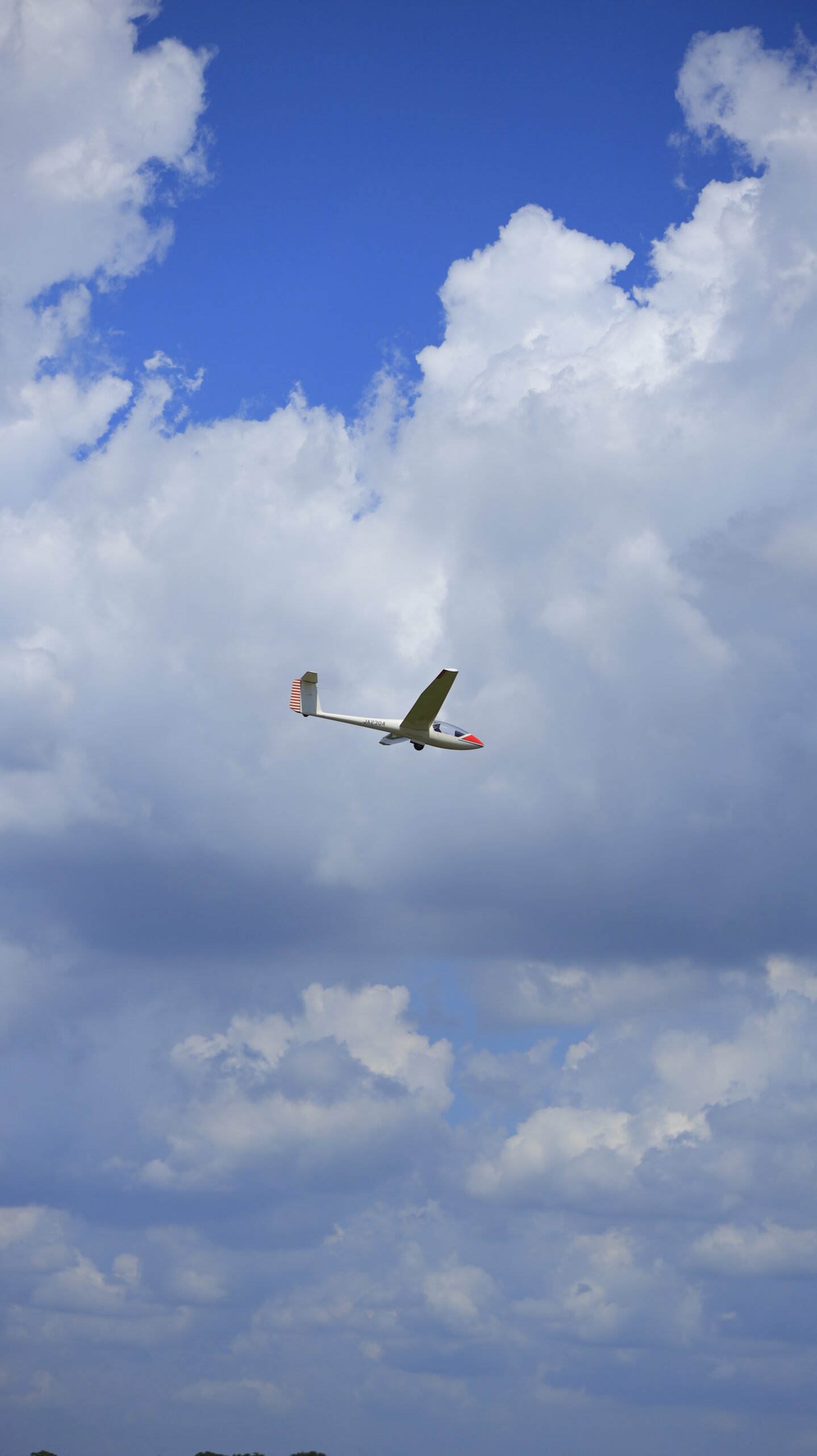 妻沼滑空場で大空を飛ぶ飛行機と綺麗な雲