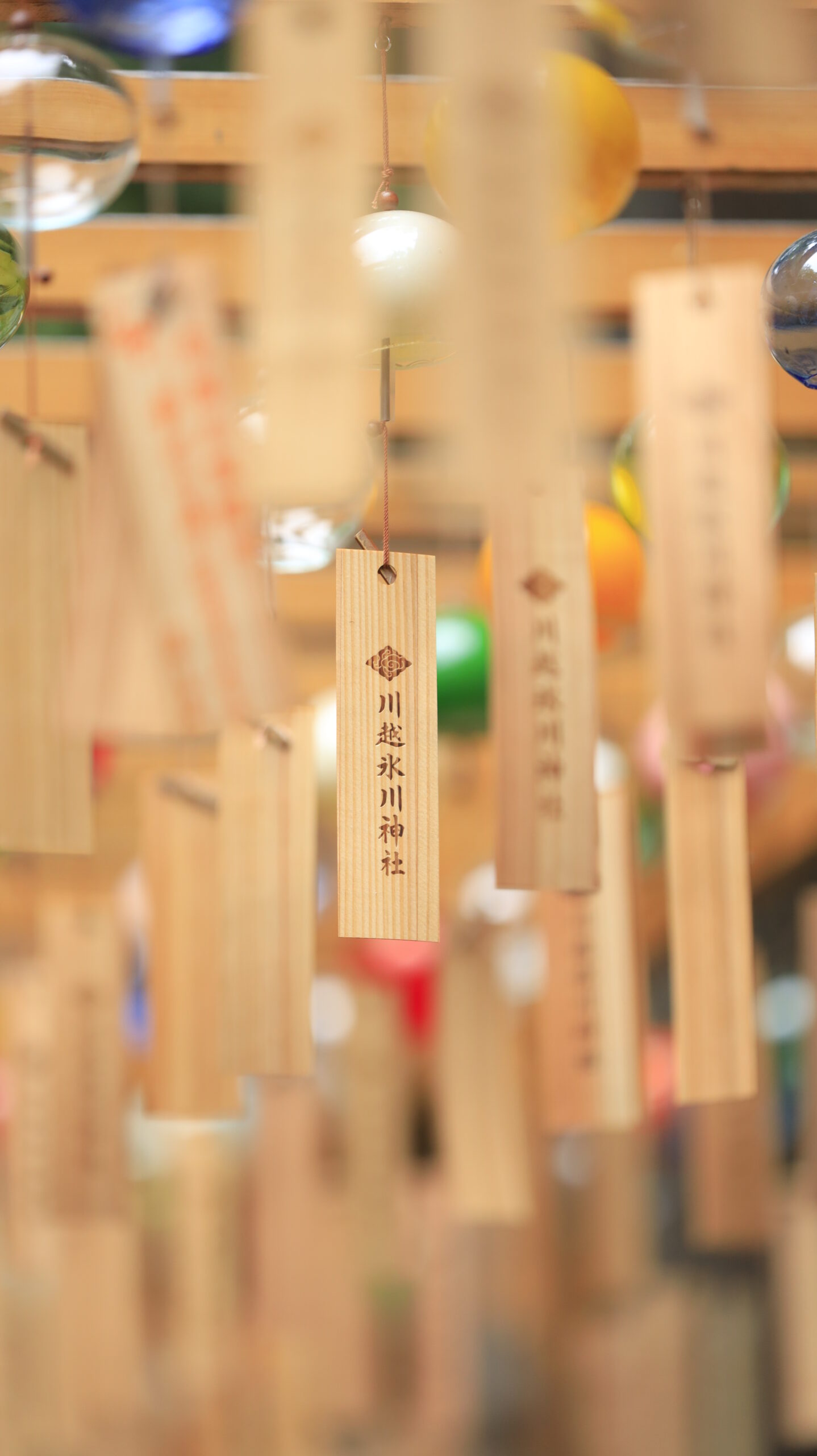 川越氷川神社で周囲のお札をぼかし、中央の神社名を浮かび上がらせた風景