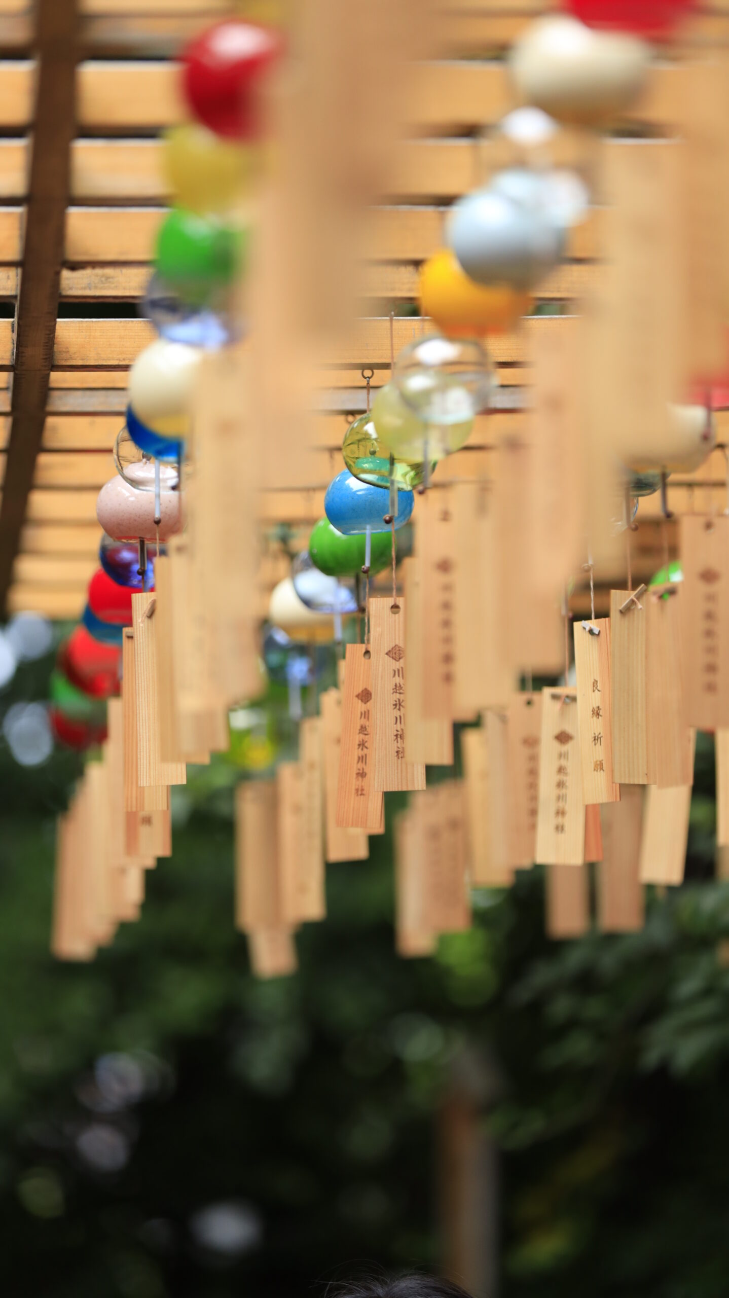 川越氷川神社で風鈴のガラスとお札を見せ、奥行きを意識して斜め左下から撮影
