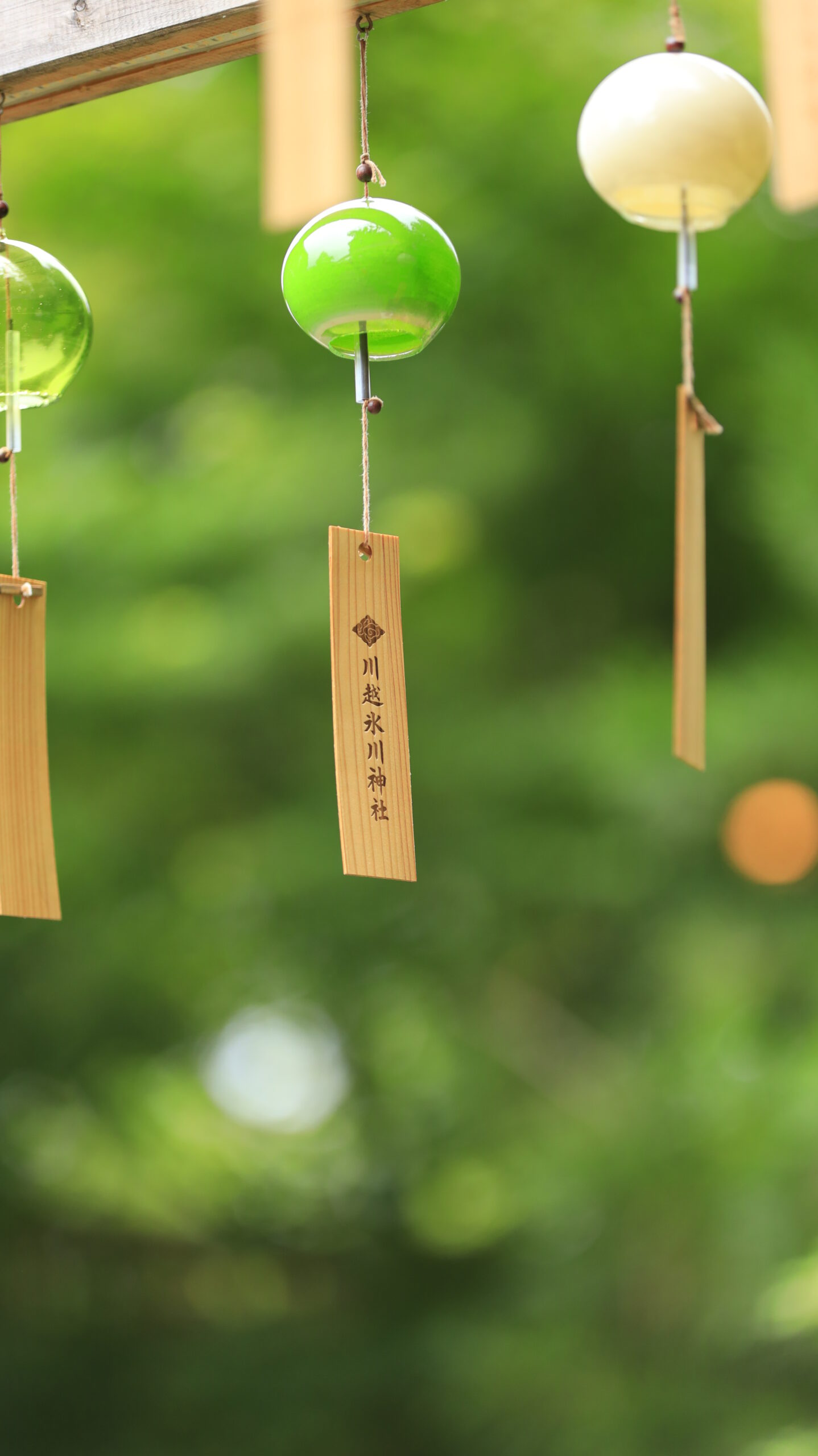 川越氷川神社で鮮やかな緑を背景に浮かび上がる透明感のある風鈴