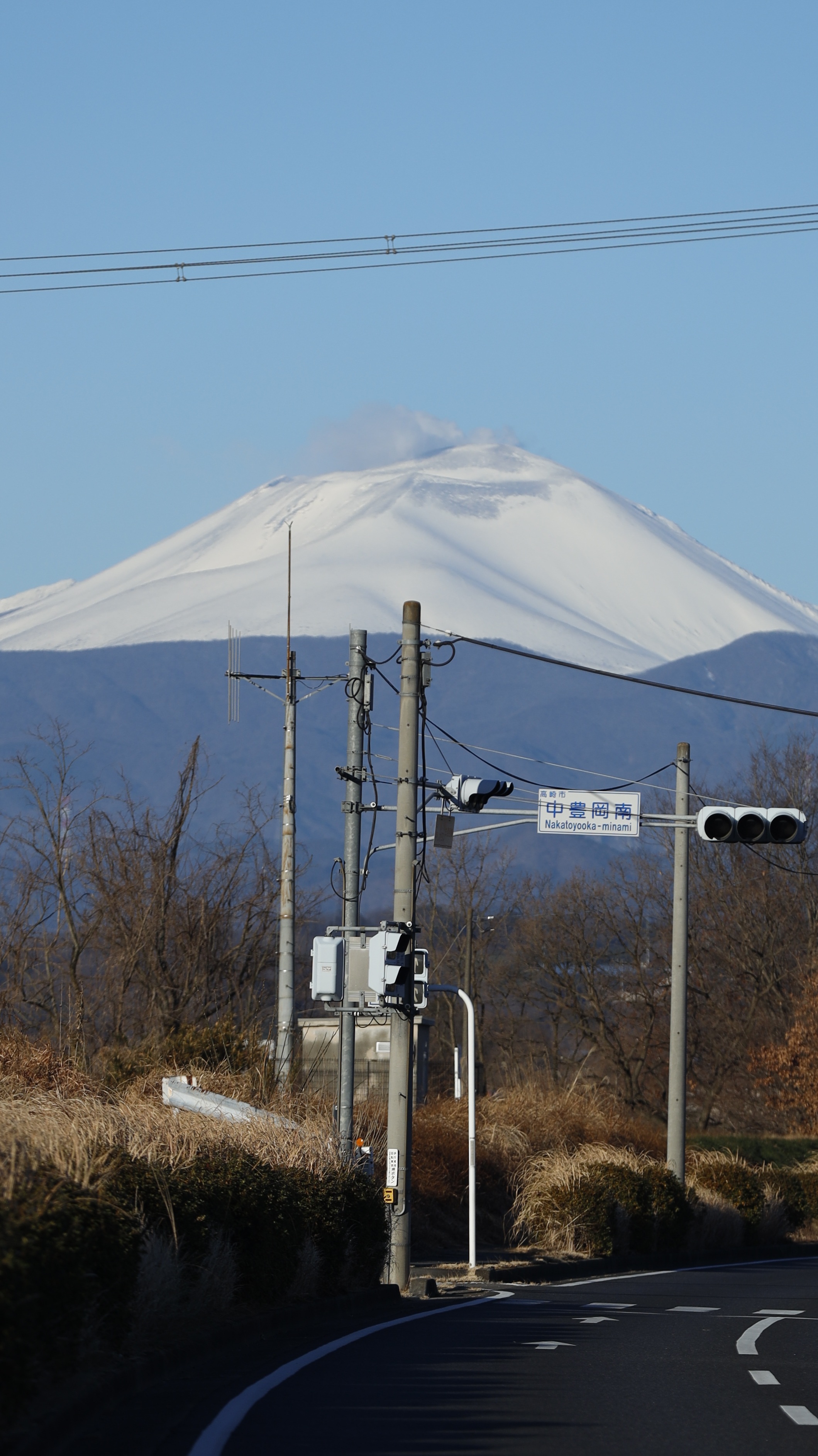 浅間山にて、「道端から見上げる雪化粧の浅間山」と感じた写真です。