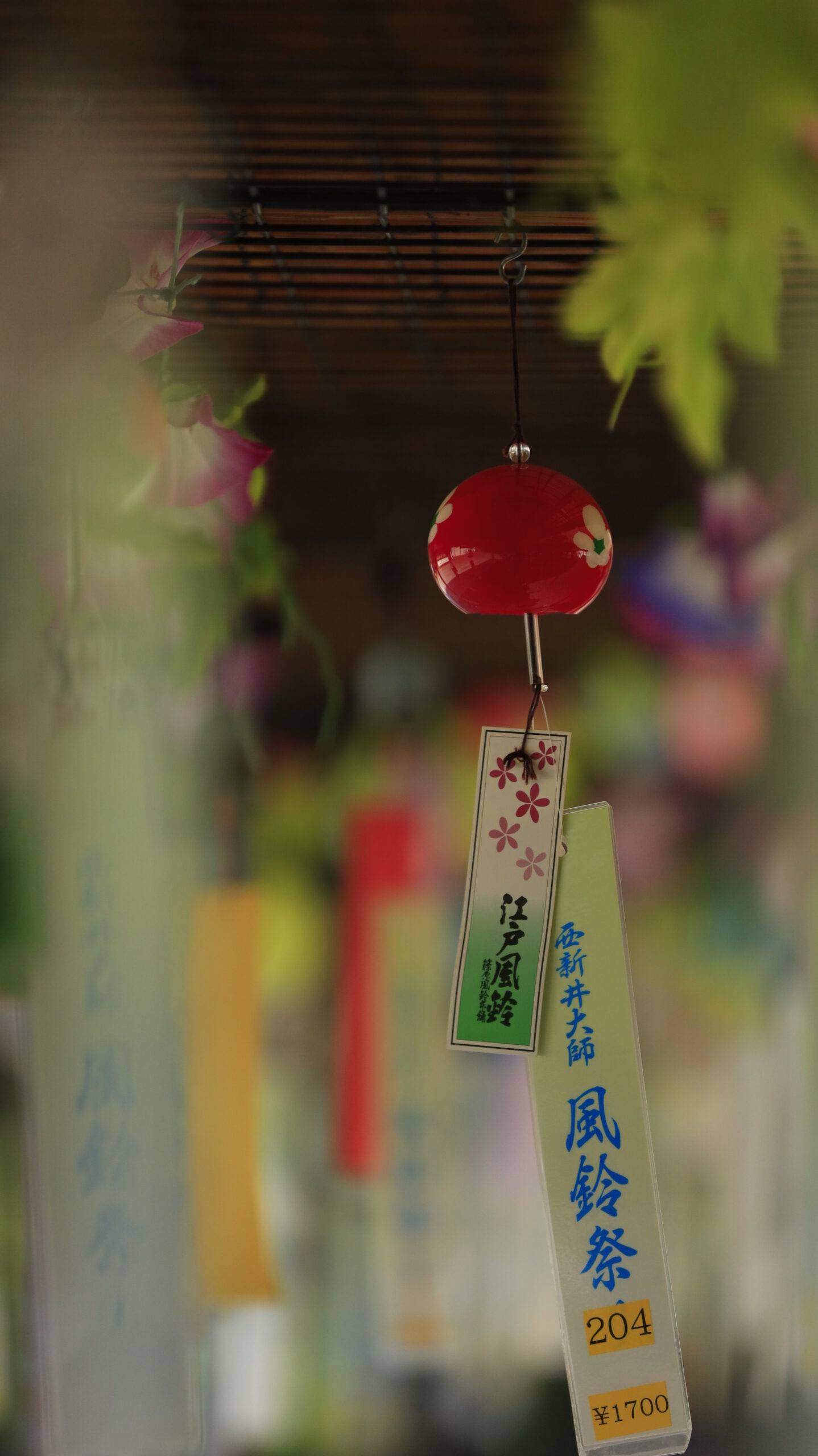 西新井大師で背景を柔らかくぼかした鮮やかな赤い江戸風鈴